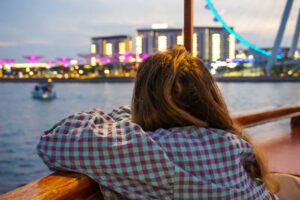 Young beautiful woman travels on an Arabic boat in Dubai Marina in Dubai, UAE,