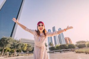 A smiling woman enjoying the vibrant atmosphere of Dubai, representing the city's appealing rental options